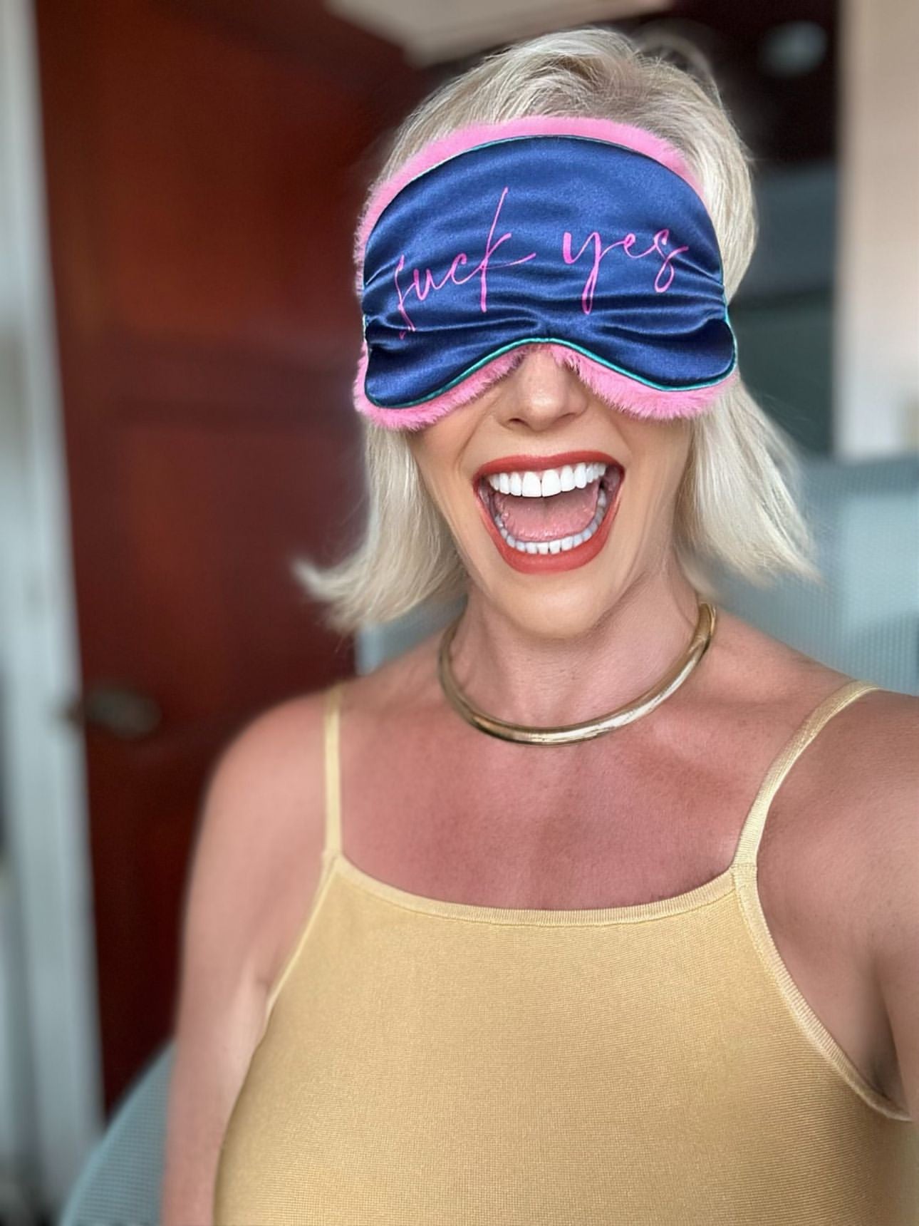 A woman wearing a blue and pink BDSM eye mask